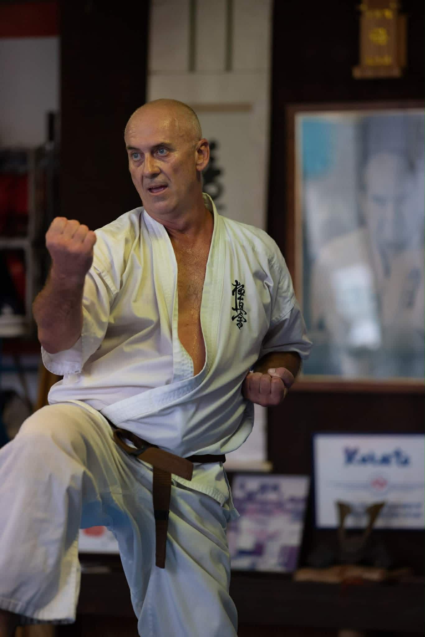 Karate instructor raising a knee while holding guard