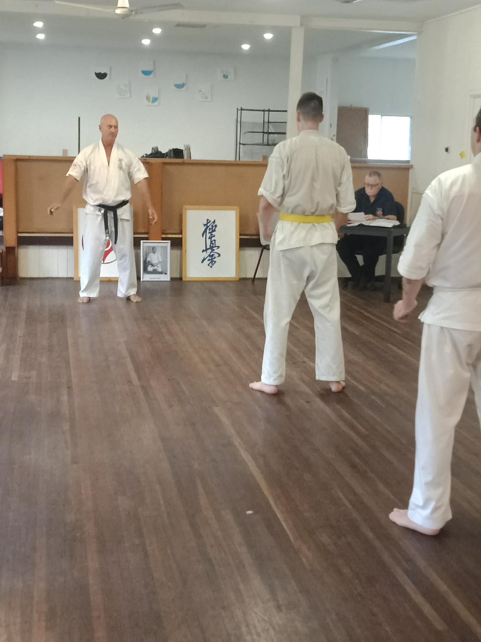 Karate students standing for instruction on the dojo floor